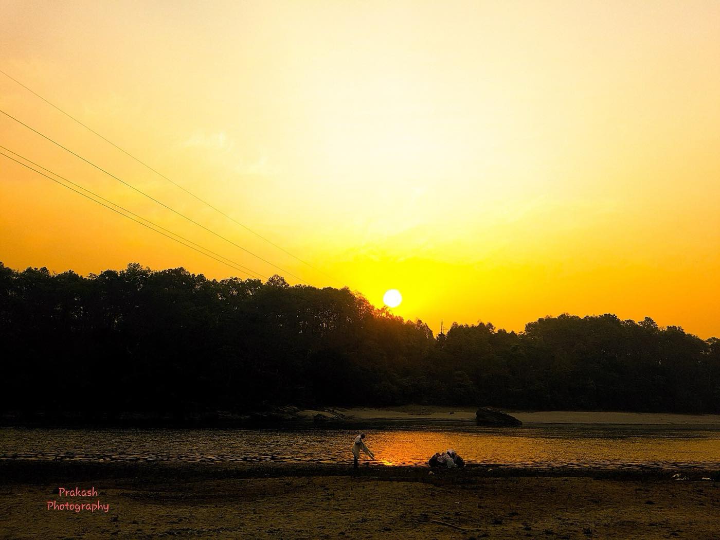The Rapti riverside at dusk with a wooden canoe drawn up on the bank