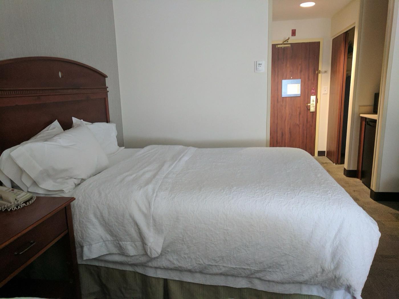 Deluxe room with a double bed, bedside lamps and a window looking onto the garden